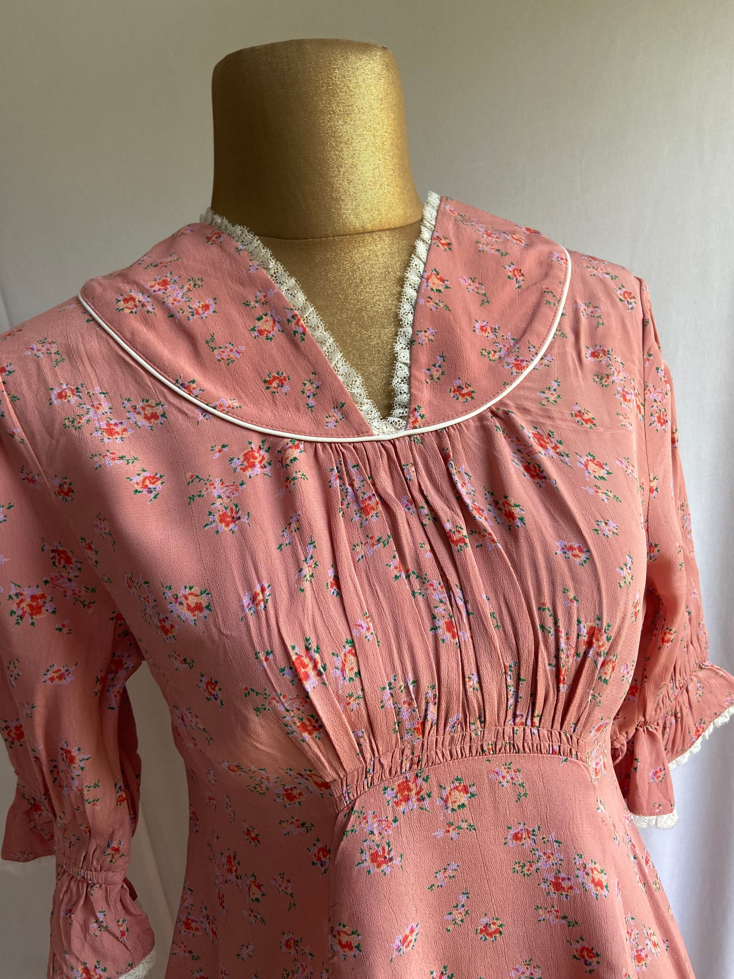 Vintage-Inspired Pink Floral Dress with Ruffled Sleeves and Lace Trim